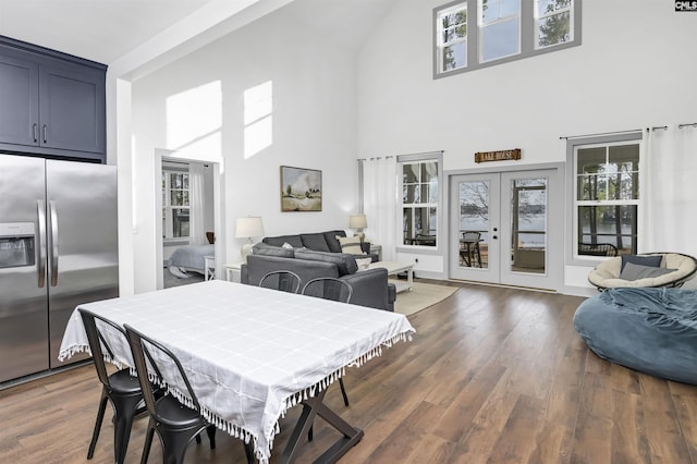 dining room featuring french doors, a towering ceiling, and dark hardwood / wood-style floors