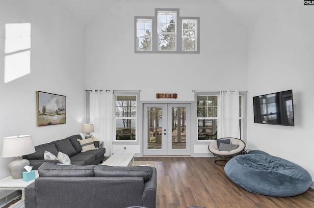 living room featuring a towering ceiling, french doors, and dark hardwood / wood-style flooring