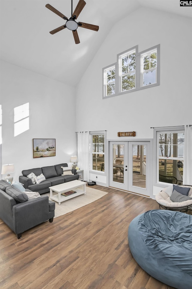 living room featuring ceiling fan, french doors, high vaulted ceiling, and wood-type flooring