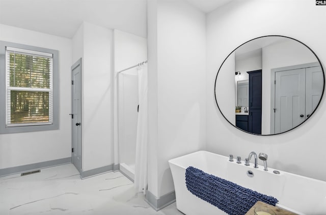 bathroom featuring shower with separate bathtub