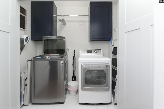 laundry area featuring washing machine and clothes dryer and cabinets