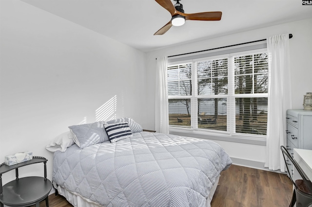 bedroom featuring multiple windows, ceiling fan, and dark hardwood / wood-style floors