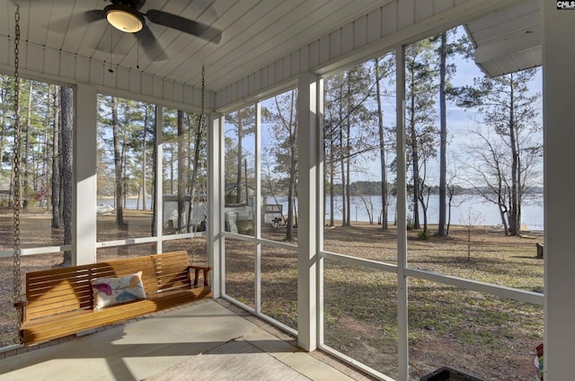 sunroom / solarium with ceiling fan and a water view