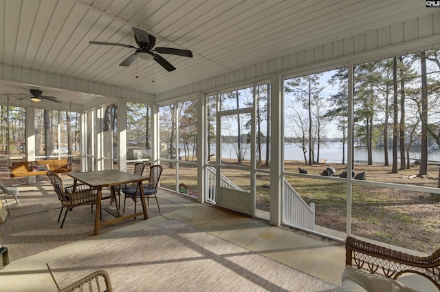 sunroom / solarium with a water view, ceiling fan, and a healthy amount of sunlight