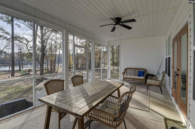 sunroom / solarium featuring ceiling fan and a water view