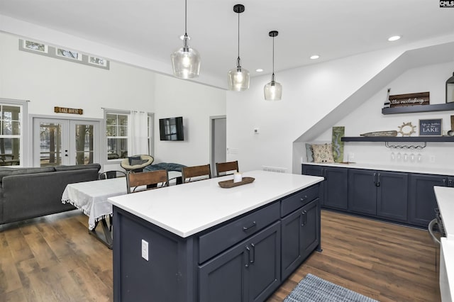 kitchen featuring dark hardwood / wood-style flooring, a center island, pendant lighting, and french doors