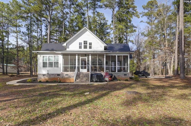 rear view of property with a sunroom and a yard