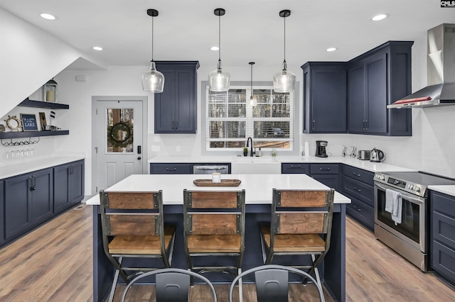 kitchen with a kitchen island, a kitchen bar, wall chimney range hood, and stainless steel appliances