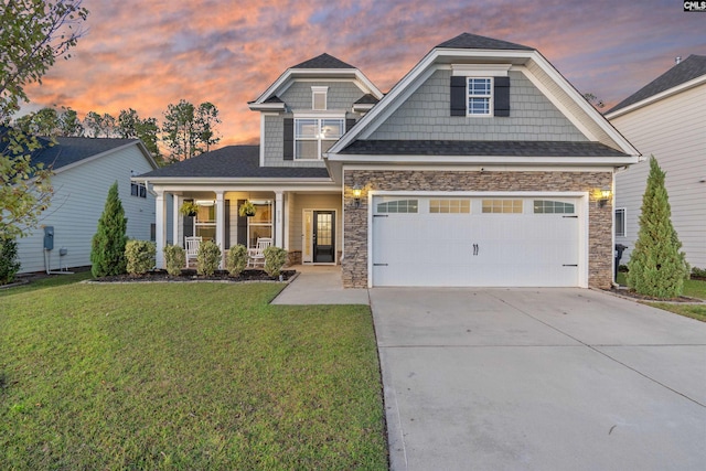 craftsman-style home featuring a lawn, a porch, and a garage