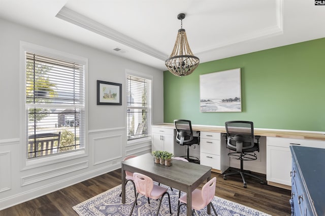 home office with a tray ceiling, built in desk, a chandelier, and dark hardwood / wood-style floors