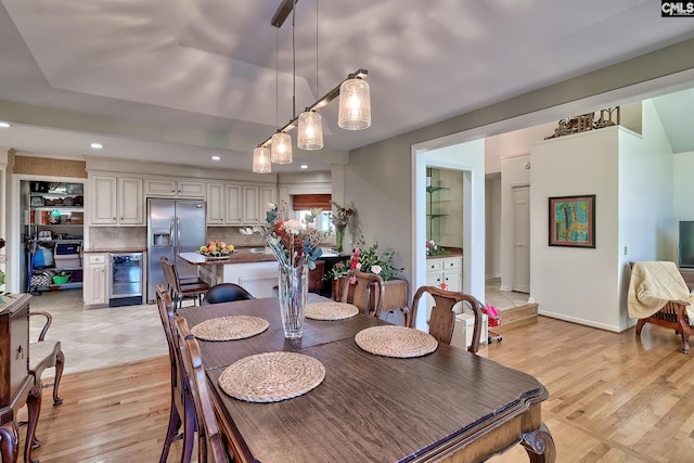 dining space with beverage cooler and light hardwood / wood-style floors