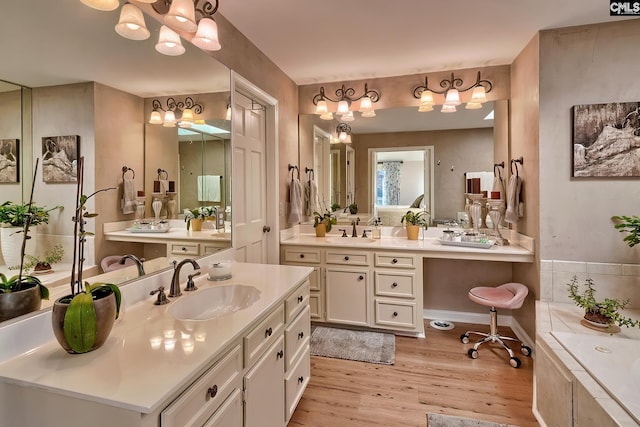 bathroom with vanity, hardwood / wood-style flooring, and a relaxing tiled tub