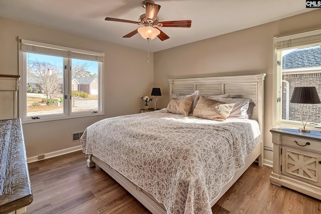 bedroom with multiple windows, ceiling fan, and hardwood / wood-style floors