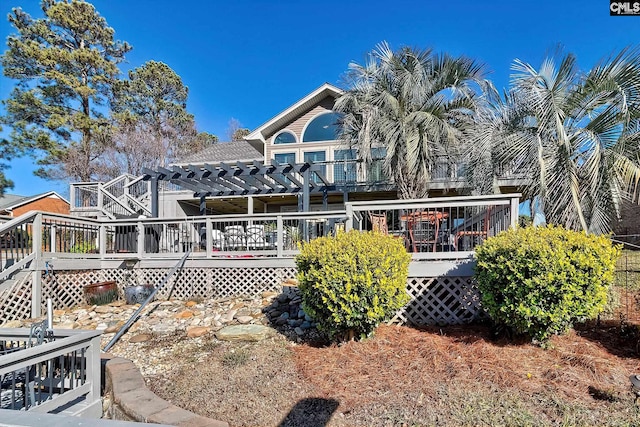 rear view of property with a pergola and a wooden deck