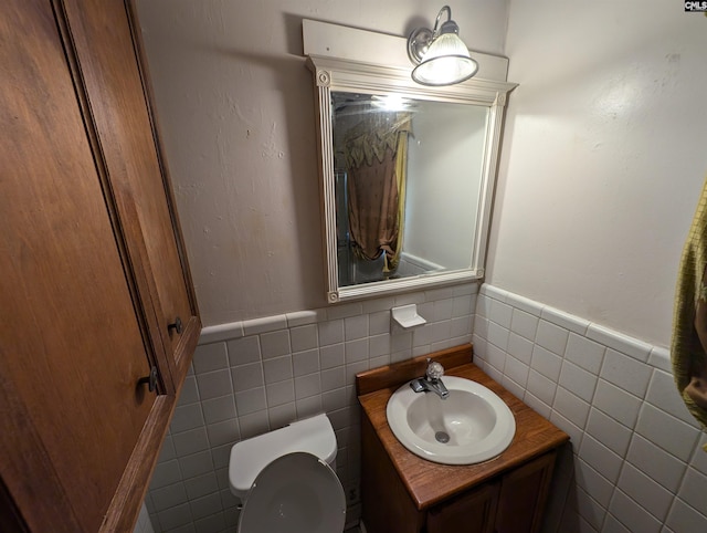 bathroom with vanity, tile walls, and toilet