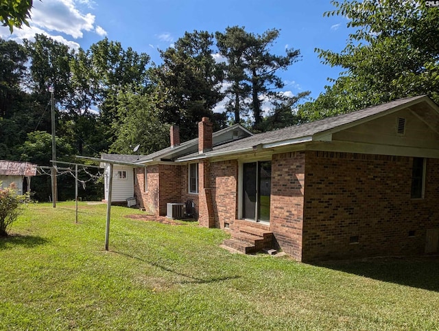 exterior space featuring cooling unit and a lawn