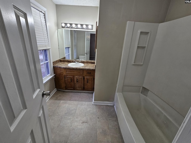 bathroom with vanity, a bathtub, and toilet