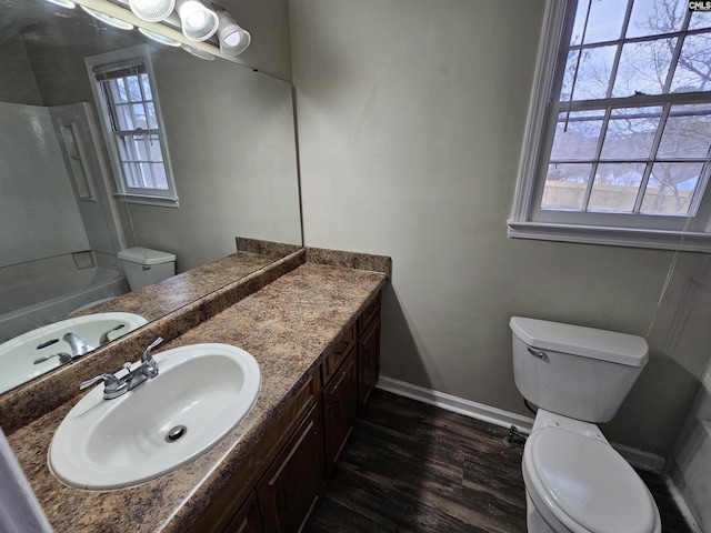 bathroom featuring hardwood / wood-style flooring, vanity, toilet, and a wealth of natural light