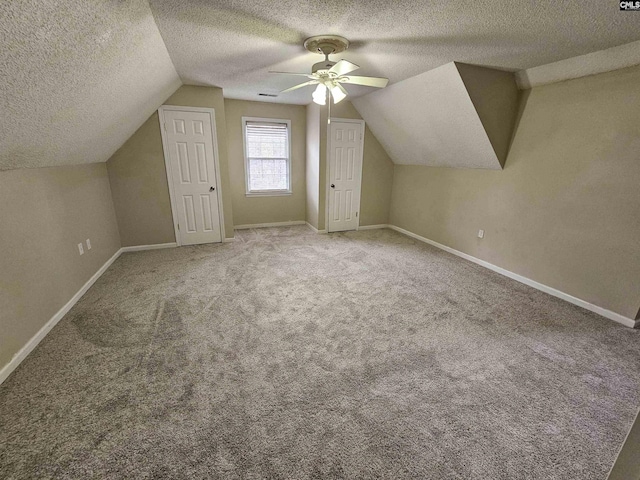 bonus room featuring ceiling fan, lofted ceiling, a textured ceiling, and carpet floors