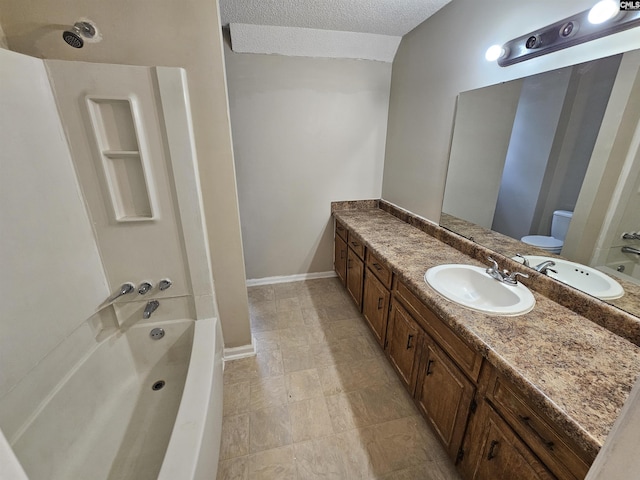 full bathroom with vanity, bathtub / shower combination, a textured ceiling, and toilet