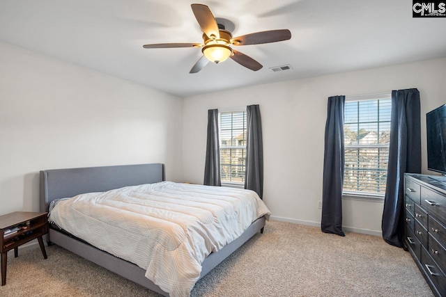 carpeted bedroom with multiple windows and ceiling fan