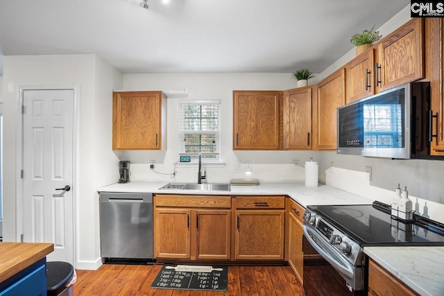 kitchen featuring hardwood / wood-style floors, appliances with stainless steel finishes, and sink