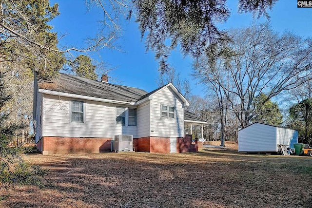 view of side of property with a storage unit and central AC