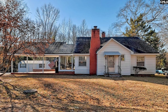 view of front facade featuring a front yard and an outbuilding