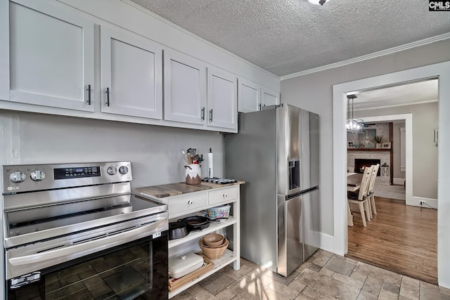 kitchen with a stone fireplace, crown molding, appliances with stainless steel finishes, a textured ceiling, and white cabinetry