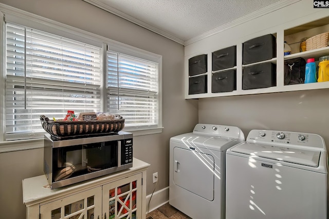 washroom featuring washing machine and dryer, ornamental molding, and a textured ceiling