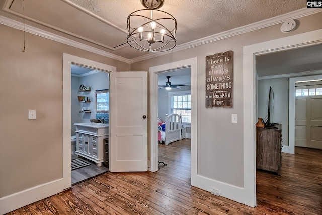 corridor with a notable chandelier, crown molding, a textured ceiling, and wood-type flooring