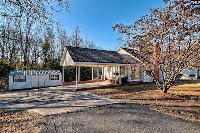 view of front facade featuring an outdoor structure, a porch, and a front lawn