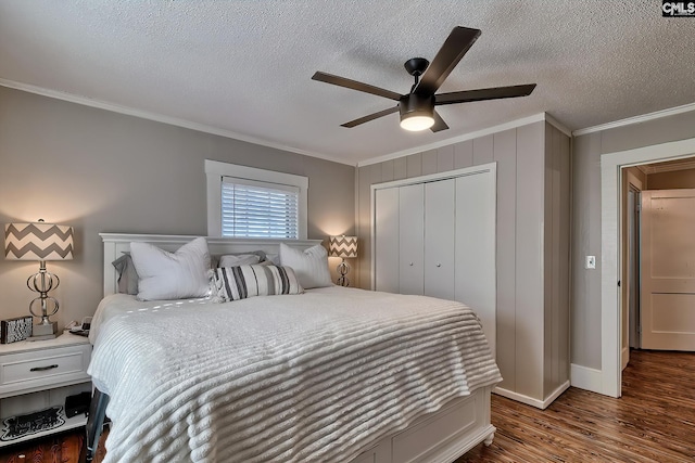 bedroom featuring a textured ceiling, dark hardwood / wood-style floors, a closet, ornamental molding, and ceiling fan