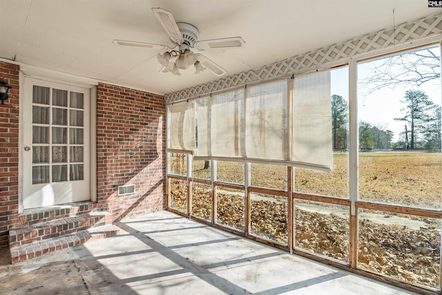 unfurnished sunroom with ceiling fan and a wealth of natural light