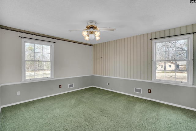 carpeted empty room with ceiling fan and a textured ceiling