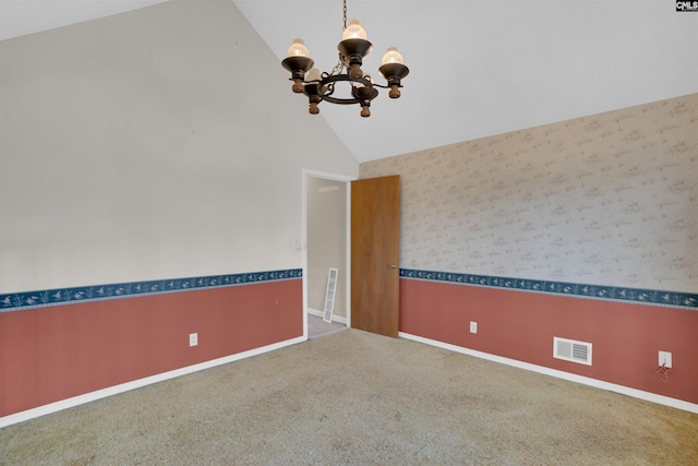 empty room featuring vaulted ceiling, a chandelier, and carpet flooring