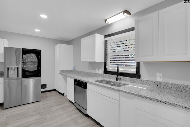 kitchen featuring sink, stainless steel appliances, light stone counters, light hardwood / wood-style flooring, and white cabinets