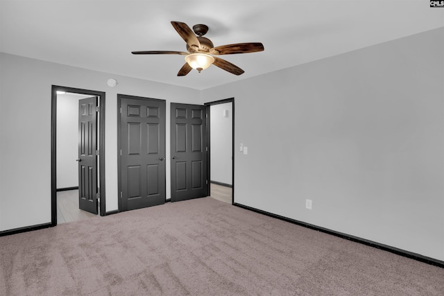 unfurnished bedroom with ceiling fan and light colored carpet