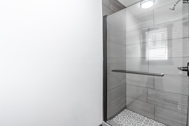 bathroom with a shower with door