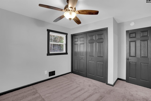 unfurnished bedroom with ceiling fan, a closet, and light colored carpet