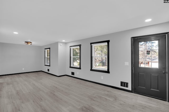 entryway with light hardwood / wood-style floors and a healthy amount of sunlight