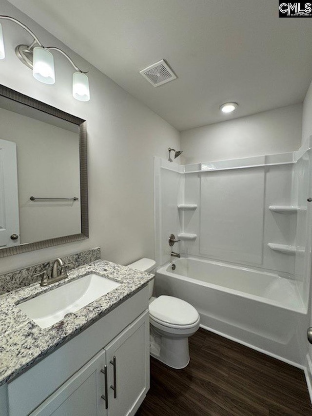 full bathroom with toilet, wood-type flooring, vanity, and shower / bathing tub combination