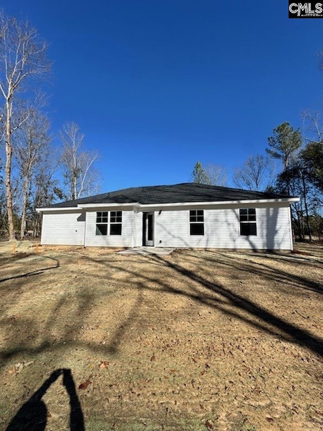 rear view of house featuring a lawn