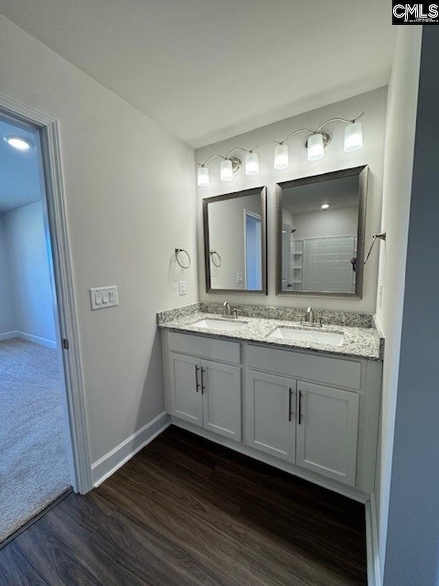 bathroom featuring walk in shower, hardwood / wood-style flooring, and vanity