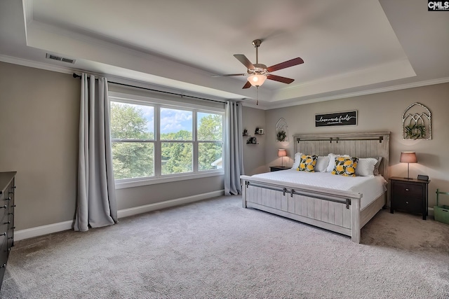 bedroom with ceiling fan, a raised ceiling, and light carpet