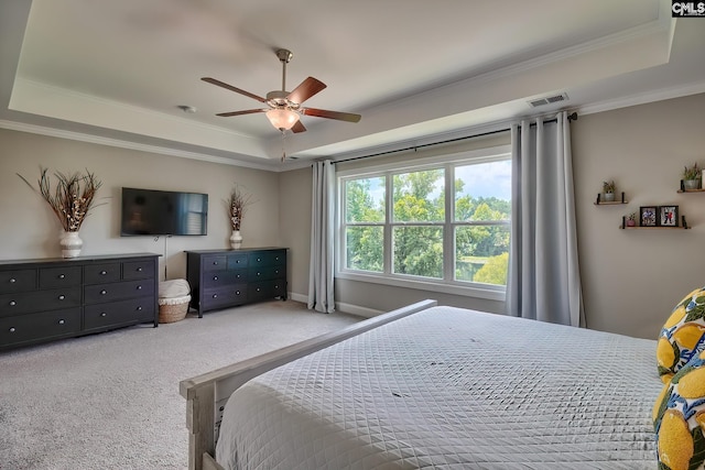 bedroom with a tray ceiling, ceiling fan, crown molding, and light colored carpet