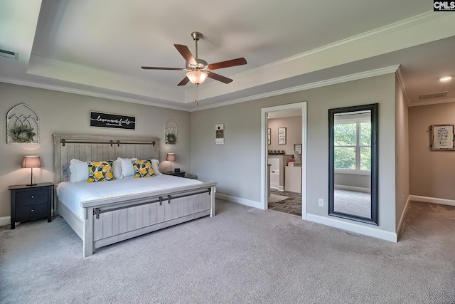 carpeted bedroom featuring ceiling fan, ornamental molding, connected bathroom, and a tray ceiling