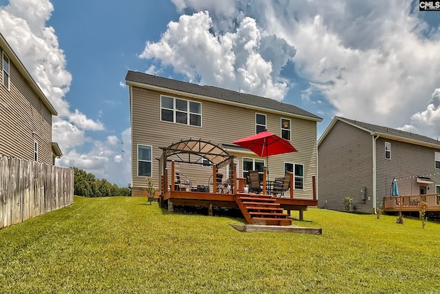 back of property with a yard and a deck