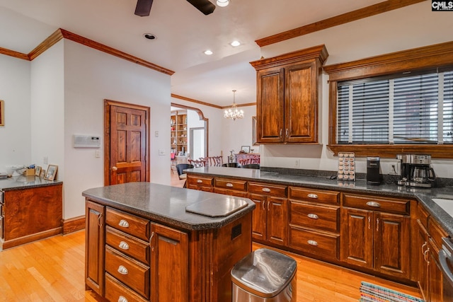 kitchen featuring light wood-type flooring, a kitchen island, and crown molding