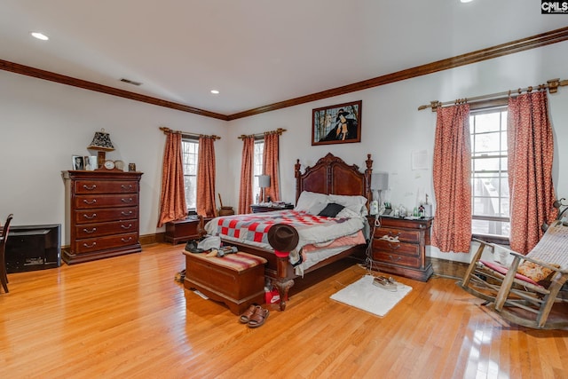 bedroom featuring multiple windows, crown molding, and light hardwood / wood-style flooring